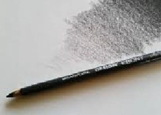 Ebony pencil resting on a shaded sheet of paper